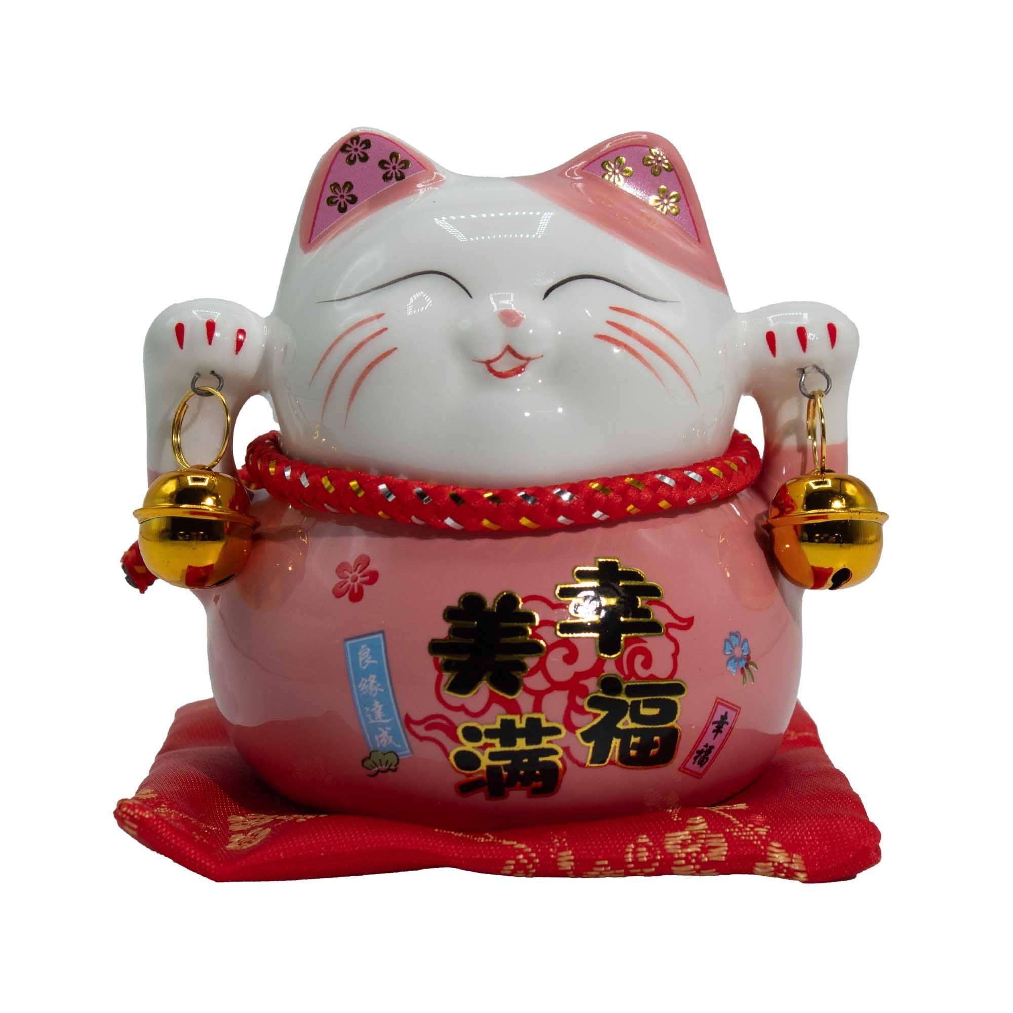 Tirelire porte-bonheur en céramique en forme de chat - rose sur un coussin