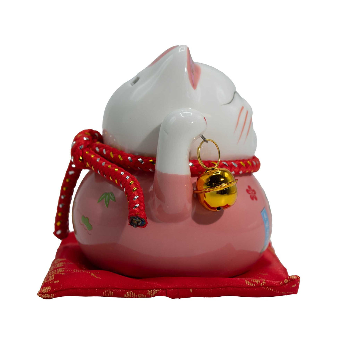 Tirelire porte-bonheur en céramique en forme de chat - rose sur un coussin