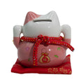 Tirelire porte-bonheur en céramique en forme de chat - rose sur un coussin