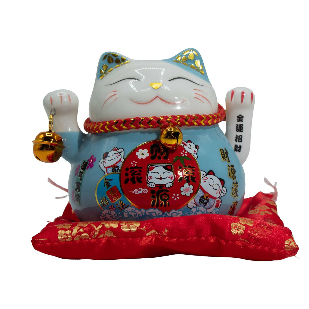 Chat porte-bonheur en céramique avec patte qui fait signe - Bleu sur coussin